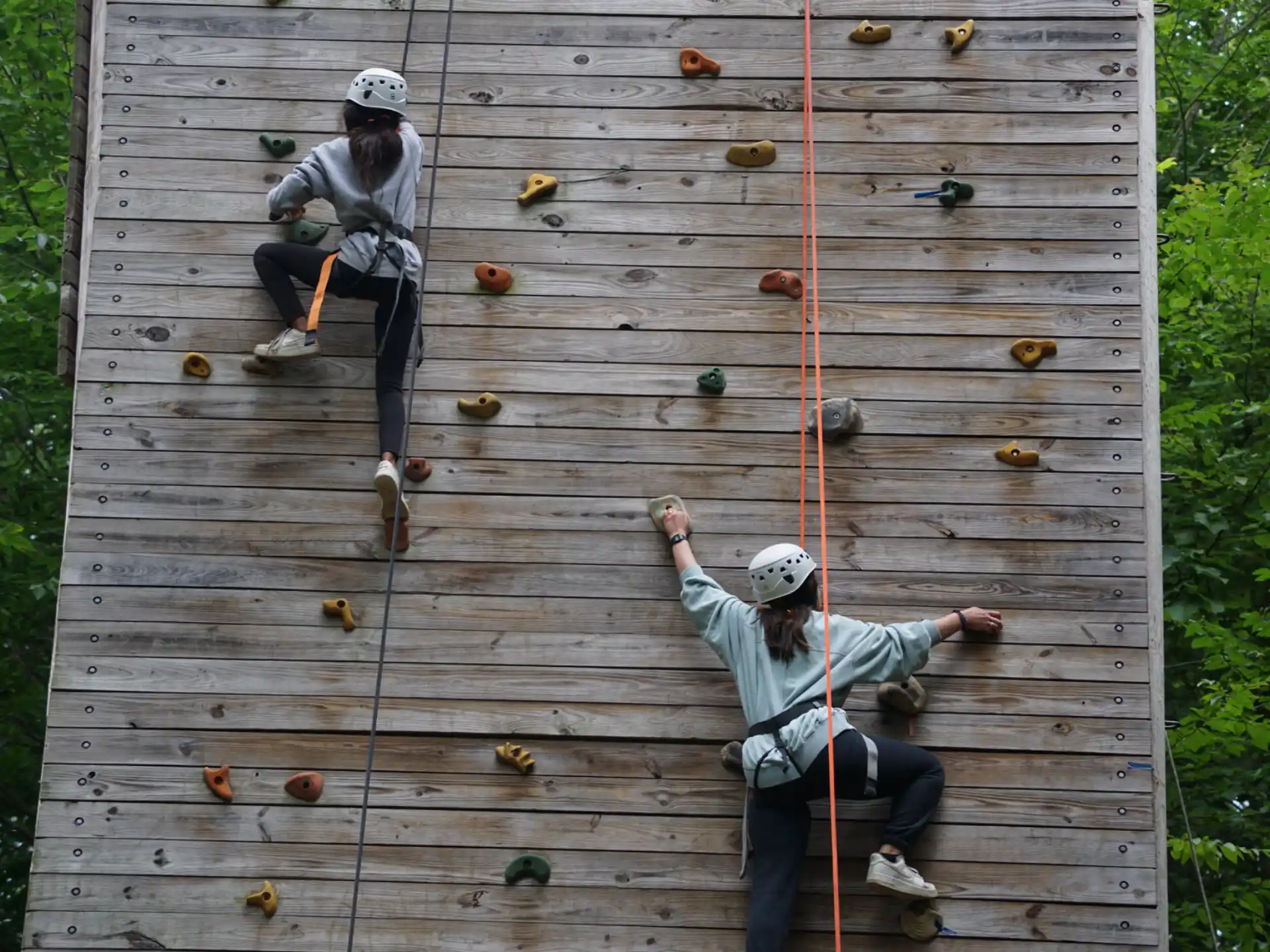a couple of people climbing a wooden deck