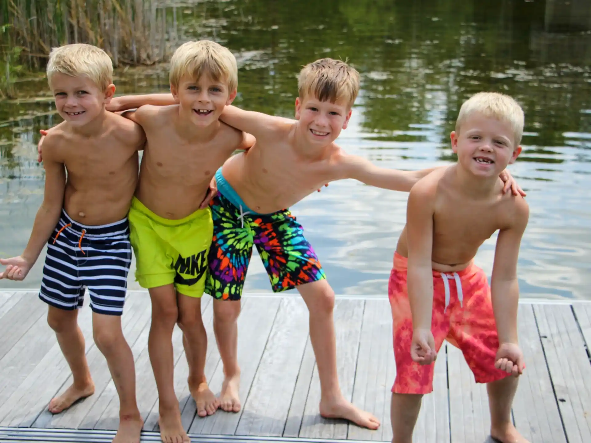 a group of boys posing for a picture on a dock