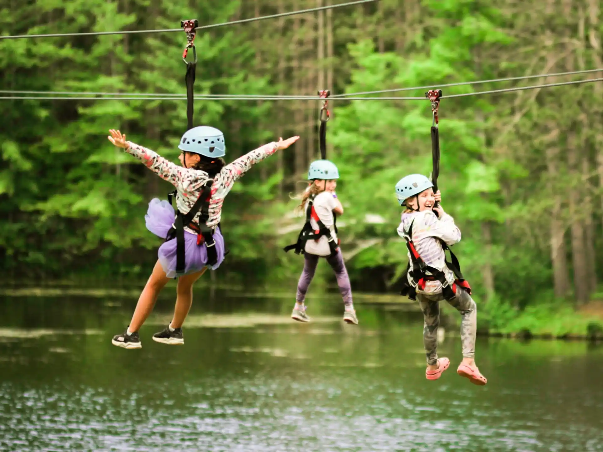 a group of people on a zip line above water